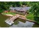 Aerial view of a waterfront property featuring a boat dock and outdoor entertainment spaces at 3125 Cardinal Lake Cir, Duluth, GA 30096