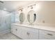 Bright bathroom featuring double sink vanity, decorative mirrors, modern lighting, and separate shower at 3125 Cardinal Lake Cir, Duluth, GA 30096