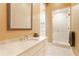 Bright bathroom featuring a glass-enclosed shower, white marble countertops, and a stylish framed mirror at 3450 Ridgewood Nw Rd, Atlanta, GA 30327
