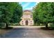A stately stone home with meticulously manicured shrubs and landscaping in this straight on view at 3450 Ridgewood Nw Rd, Atlanta, GA 30327