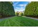 A perfectly manicured lawn leads up to the distinguished home, framed by tall, mature trees at 3450 Ridgewood Nw Rd, Atlanta, GA 30327