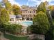 Rear view of a home with a pristine in-ground pool, cabana, and a domed gazebo at 3450 Ridgewood Nw Rd, Atlanta, GA 30327