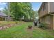 A spacious, grassy backyard features a fire pit, grill, and views of mature trees surrounding the property at 3470 Whisperwood Nw Ct, Marietta, GA 30064