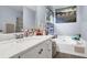 Bright bathroom featuring a marble vanity top, a soaking tub, and a decorative, colorful accent wall at 3470 Whisperwood Nw Ct, Marietta, GA 30064