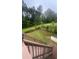 A view from the wooden deck stairs with lush green lawn surrounded by mature trees in the backyard at 585 Station View Run, Lawrenceville, GA 30043