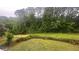A well-maintained lawn provides a serene backyard setting with lush greenery and a newly-installed fence for privacy at 585 Station View Run, Lawrenceville, GA 30043