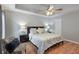 Spacious bedroom featuring neutral walls, ceiling fan, plush bedding, and comfortable seating area for relaxation at 585 Station View Run, Lawrenceville, GA 30043