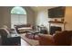 Cozy living room features fireplace, neutral walls, plush seating and large window for ample natural light at 585 Station View Run, Lawrenceville, GA 30043