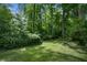 Large backyard featuring green grass surrounded by woods and trees that offers privacy and plenty of space for outdoor activities at 2175 Fisher Ne Trl, Atlanta, GA 30345