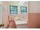 Retro pink bathroom features a tiled shower and vanity with natural light from the window at 2175 Fisher Ne Trl, Atlanta, GA 30345