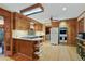 Eat-in kitchen featuring wood cabinets, hardwood floors, an island cooktop, and modern appliances for meal preparation at 2175 Fisher Ne Trl, Atlanta, GA 30345