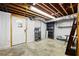 Unfinished basement with concrete floor, painted walls, exposed ceiling, and doorway to outside at 2315 Tuxedo Se Dr, Marietta, GA 30067