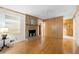 Cozy living room featuring a brick fireplace, hardwood floors, and built in shelving at 2315 Tuxedo Se Dr, Marietta, GA 30067