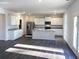 Open-concept kitchen features an island, stainless steel appliances, and white cabinets at 2701 Montie Ct, Lithia Springs, GA 30122