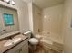 Bathroom with tile floors features a granite-look vanity and tub with shower at 6026 Woodcreek Dr, Woodstock, GA 30188