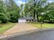 Charming single-Gathering home with a two-car garage and a well-maintained front yard surrounded by mature trees at 6026 Woodcreek Dr, Woodstock, GA 30188