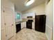 Efficient kitchen with white cabinetry, black appliances, and durable tiled floor, perfect for everyday living at 6026 Woodcreek Dr, Woodstock, GA 30188