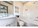 Bright bathroom with a combined shower and tub, white cabinets, and tiled walls at 661 Auburn Ne Ave # 10, Atlanta, GA 30312