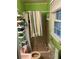 Compact bathroom with a shower stall, window, and shelving at 1481 Pine St, Stone Mountain, GA 30087