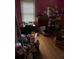 Cluttered bedroom with pink walls, hardwood floors, and a dresser at 1481 Pine St, Stone Mountain, GA 30087