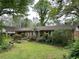 Exterior view of home with covered parking on an overgrown lot at 1481 Pine St, Stone Mountain, GA 30087