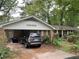 Exterior view of the home with covered parking, and overgrown front yard and hedges at 1481 Pine St, Stone Mountain, GA 30087