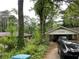 Exterior of home with covered parking, overgrown front yard, driveway, and two vehicles at 1481 Pine St, Stone Mountain, GA 30087