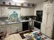 Galley kitchen features white cabinets, appliances and sink under a window at 1481 Pine St, Stone Mountain, GA 30087