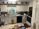 Kitchen featuring white cabinets, appliances, tile floor and sink under a window at 1481 Pine St, Stone Mountain, GA 30087