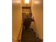 Personal walking down dimly lit carpeted stairs with a wooden handrail at 1481 Pine St, Stone Mountain, GA 30087