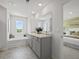 Bright bathroom featuring double sinks, sleek vanity, large tub and large window at 2709 Montie Ct, Lithia Springs, GA 30122