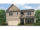 Charming two-story home featuring a neutral color palette, inviting front porch, and attached two-car garage at 2709 Montie Ct, Lithia Springs, GA 30122