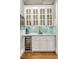 Stylish bar area with white cabinets, wine fridge, and decorative tile backsplash at 2870 Redding Ne Rd, Atlanta, GA 30319