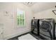 Modern laundry room featuring stainless steel washer and dryer, and black tile floors at 2870 Redding Ne Rd, Atlanta, GA 30319