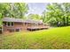 This backyard features a brick home with a spacious wooden deck and well-maintained lawn at 4201 Hicks Rd, Austell, GA 30106
