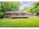 A cozy brick home with a wooden deck and lush green backyard, perfect for outdoor entertaining at 4201 Hicks Rd, Austell, GA 30106