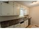 Functional kitchen showcasing dark countertops, white cabinets, and a window view at 4201 Hicks Rd, Austell, GA 30106