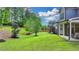 Landscaped backyard with mature trees providing shade and privacy, and a covered patio at 13055 Fox Rd, Alpharetta, GA 30005