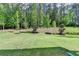 Lush backyard featuring mature trees and a gentle slope, offering both privacy and natural beauty at 13055 Fox Rd, Alpharetta, GA 30005