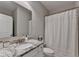 Bright bathroom featuring a granite countertop, white cabinets, and a shower-tub combo with a stylish curtain at 13055 Fox Rd, Alpharetta, GA 30005