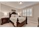 Cozy guest bedroom with a wood-framed bed, side tables, and a window with plantation shutters at 13055 Fox Rd, Alpharetta, GA 30005