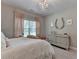 Bright bedroom has natural light from the large window and neutral decor with a chandelier at 13055 Fox Rd, Alpharetta, GA 30005