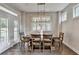 Dining area featuring a wooden table set, modern light fixture, and natural light from windows and doors at 13055 Fox Rd, Alpharetta, GA 30005