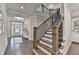 Elegant foyer with hardwood floors, a staircase with black iron railings, and a view of the front door at 13055 Fox Rd, Alpharetta, GA 30005