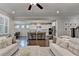 Open-concept living room showcases the kitchen with white cabinets, a central island, and comfortable sofas at 13055 Fox Rd, Alpharetta, GA 30005