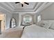 Serene main bedroom featuring a tray ceiling, carpeted floors, and stylish seating area, creating a relaxing space at 13055 Fox Rd, Alpharetta, GA 30005