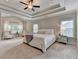 Large main bedroom with a tray ceiling, carpet, and elegant furniture, creating a relaxing retreat at 13055 Fox Rd, Alpharetta, GA 30005