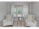 Cozy sitting area with tufted chairs, a small table, and bright windows offering natural light and a pleasant view at 13055 Fox Rd, Alpharetta, GA 30005