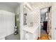 Bright bathroom with a spacious countertop, vintage wall coverings, and an adjacent shower and toilet at 3456 Paces Nw Pl, Atlanta, GA 30327