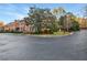 Brick townhome with mature landscaping and a roundabout entrance drive on a sunny day at 3456 Paces Nw Pl, Atlanta, GA 30327